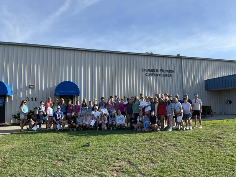 Large group of people posing in front of the Loomis E. Blinson Civitan Center on a sunny day